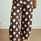 Front view of brown jeans with oversized white polka dots and front patch pockets